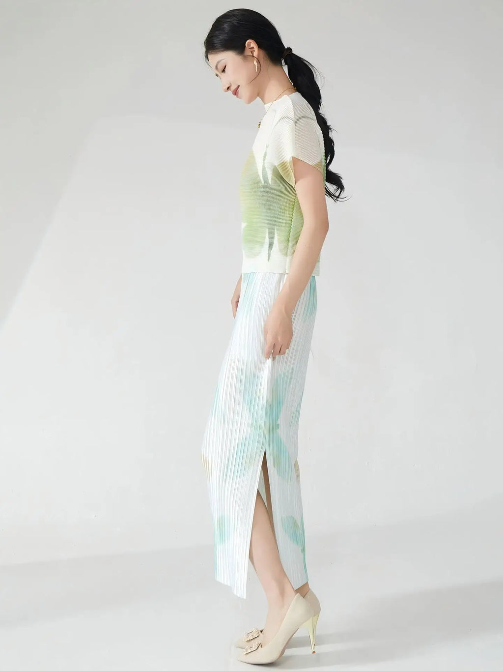 Summer women's outfit: a stylish two-piece set including a short-sleeved T-shirt and a pleated midi skirt with a slit.