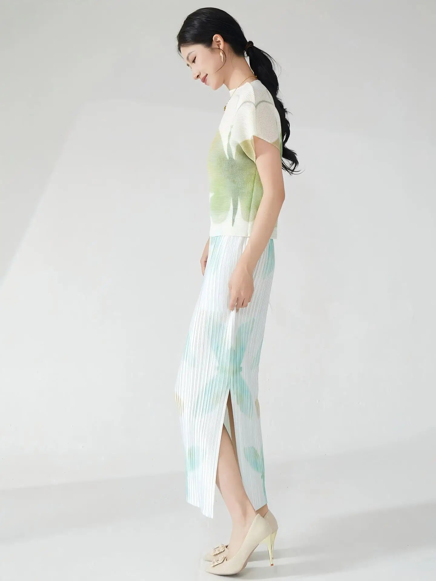 Summer women's outfit: a stylish two-piece set including a short-sleeved T-shirt and a pleated midi skirt with a slit.
