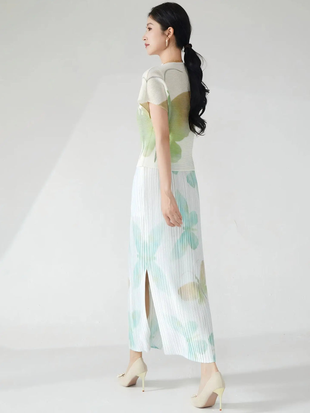 Summer women's outfit: a stylish two-piece set including a short-sleeved T-shirt and a pleated midi skirt with a slit.