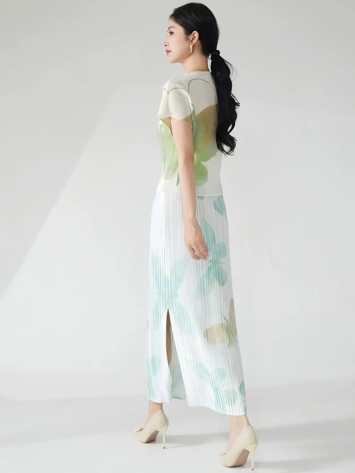Summer women's outfit: a stylish two-piece set including a short-sleeved T-shirt and a pleated midi skirt with a slit.