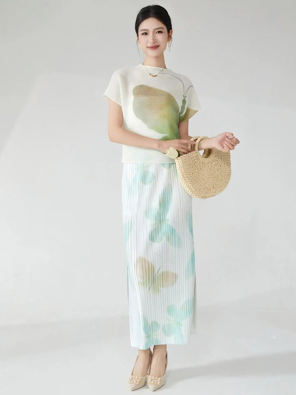 Summer women's outfit: a stylish two-piece set including a short-sleeved T-shirt and a pleated midi skirt with a slit.