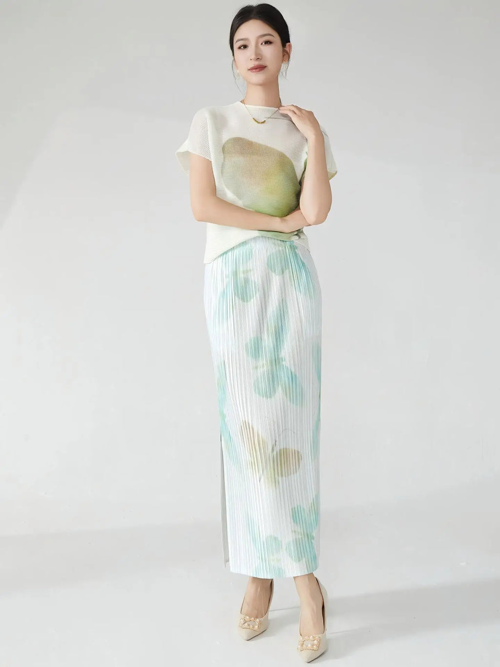 Summer women's outfit: a stylish two-piece set including a short-sleeved T-shirt and a pleated midi skirt with a slit.